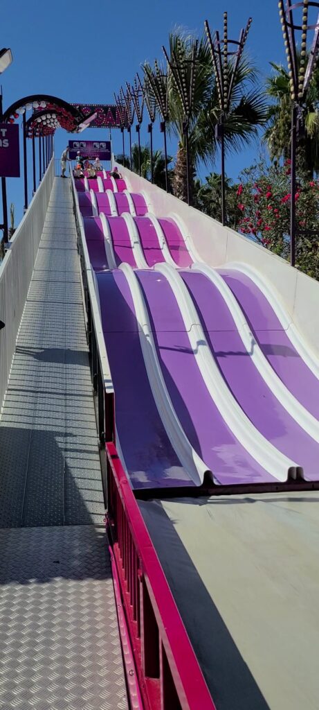 Enfants glissant sur des tapis dans un grand toboggan coloré